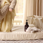 A baby changing on top of a changing cushion in daisy meadow print