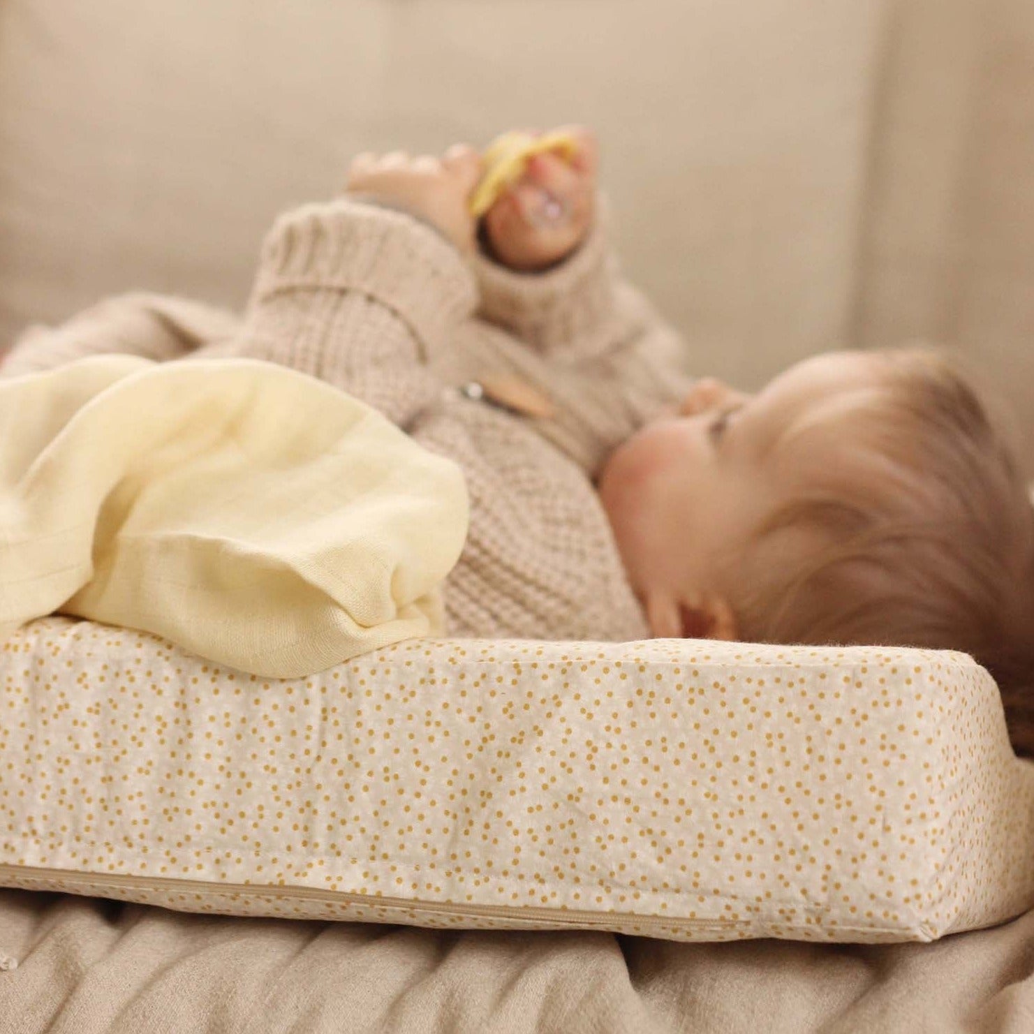 A baby lying on top of changing cushion daisy meadow