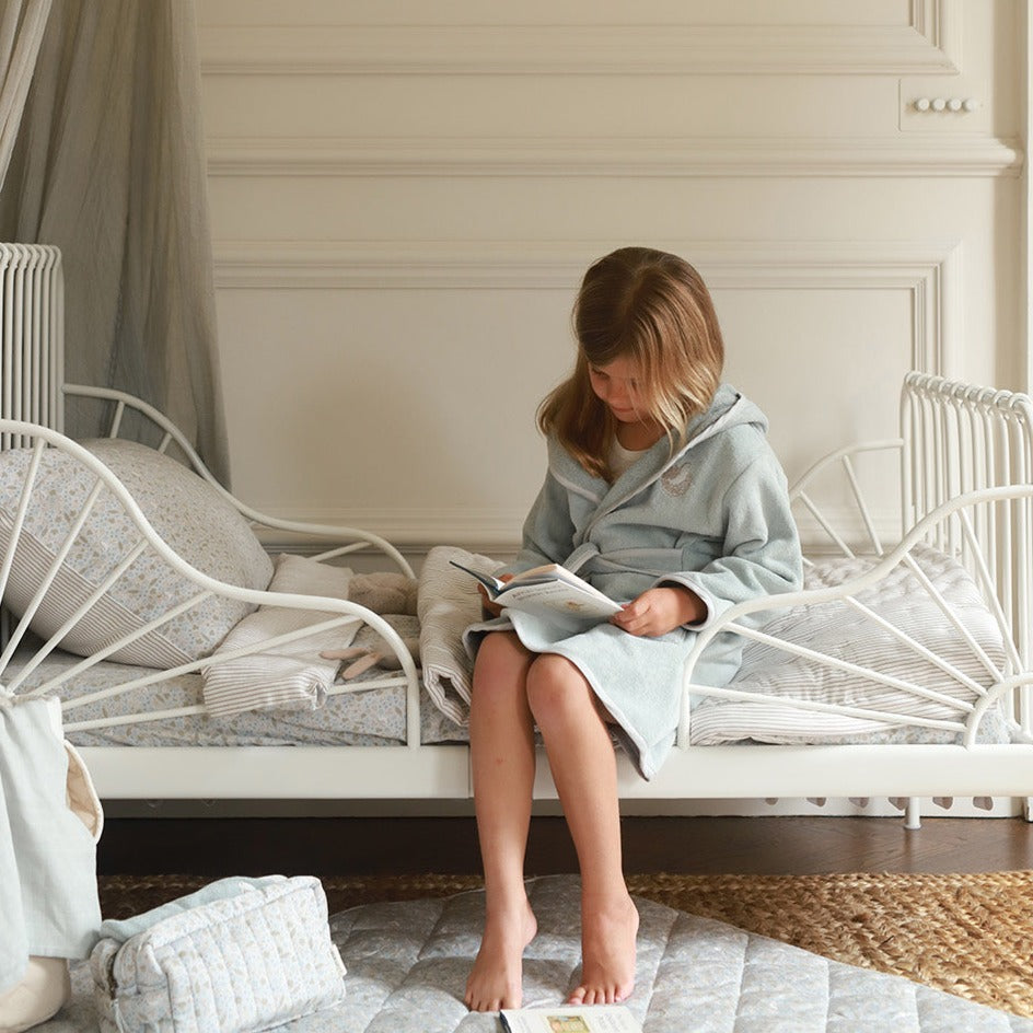 A girl wearing towelling robe quail while reading