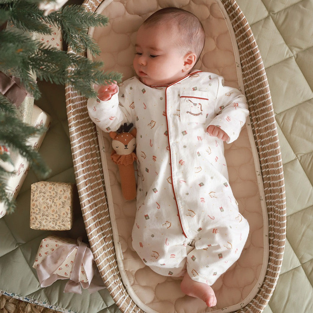 Baby wearing sleepsuit nutcracker lying on a changing basket
