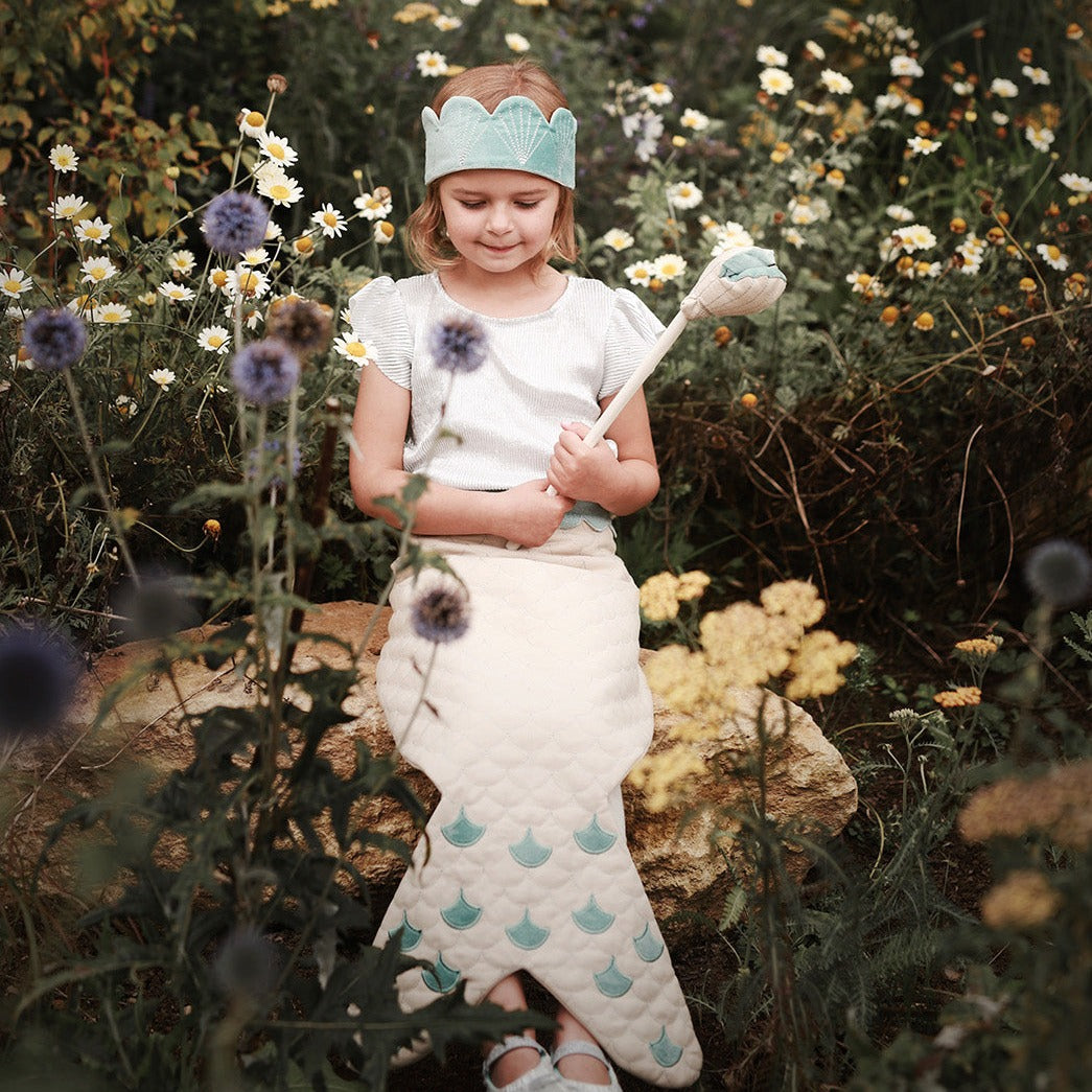 3 piece set contains a sea-blue velvet crown, pretty shell wand with a pop out pearl, and beautiful wrap around tail worn by a girl sitting on a rock